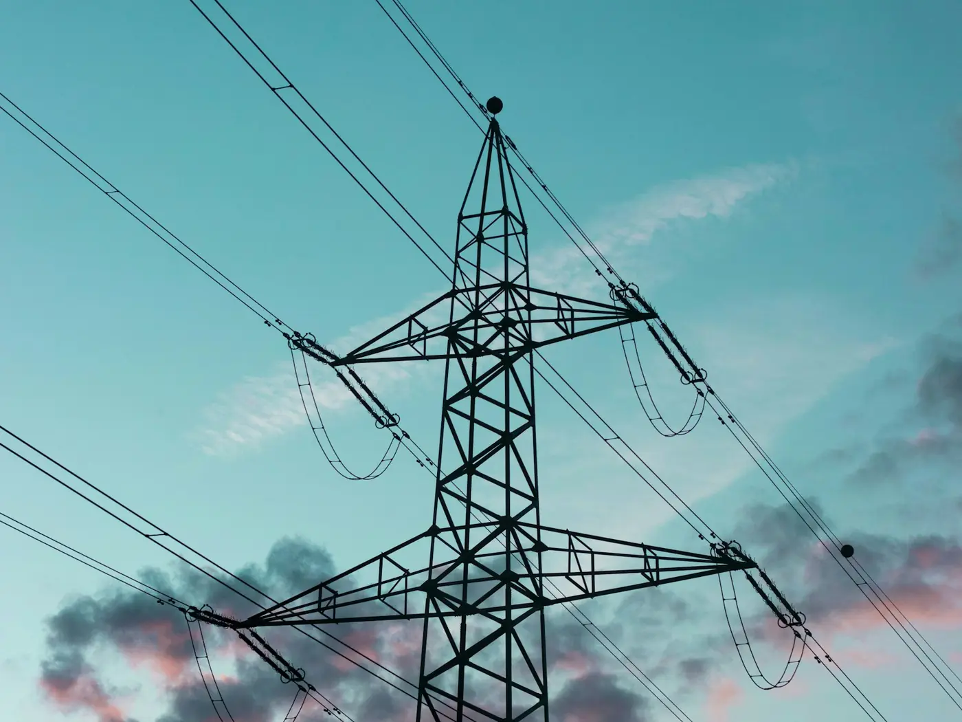 A steel transmission pylon and conductors against a blue sky