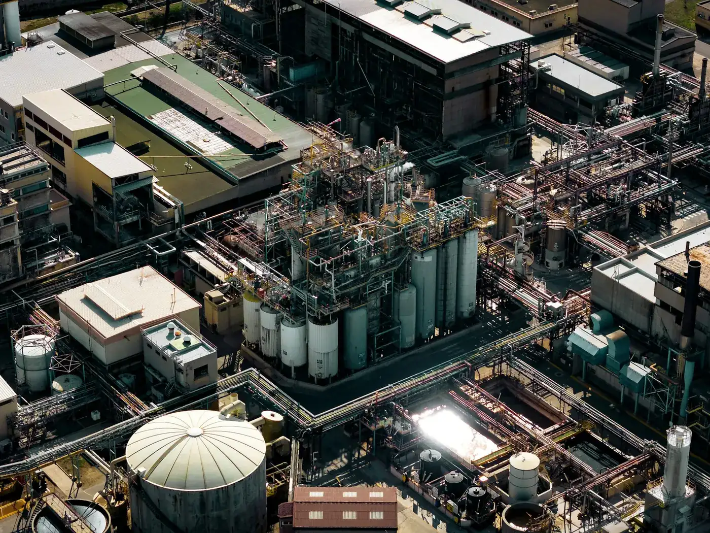 Aerial view of a process plant with tanks, pipework and stacks