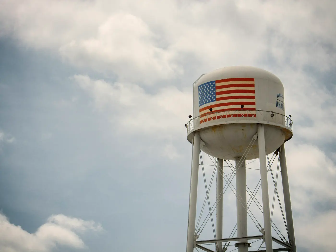 An elevated steel water tower against cloud