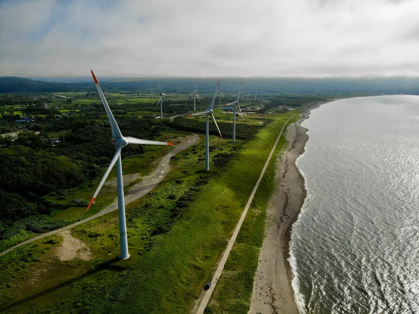 Wind turbines along a coastline, seen from the air