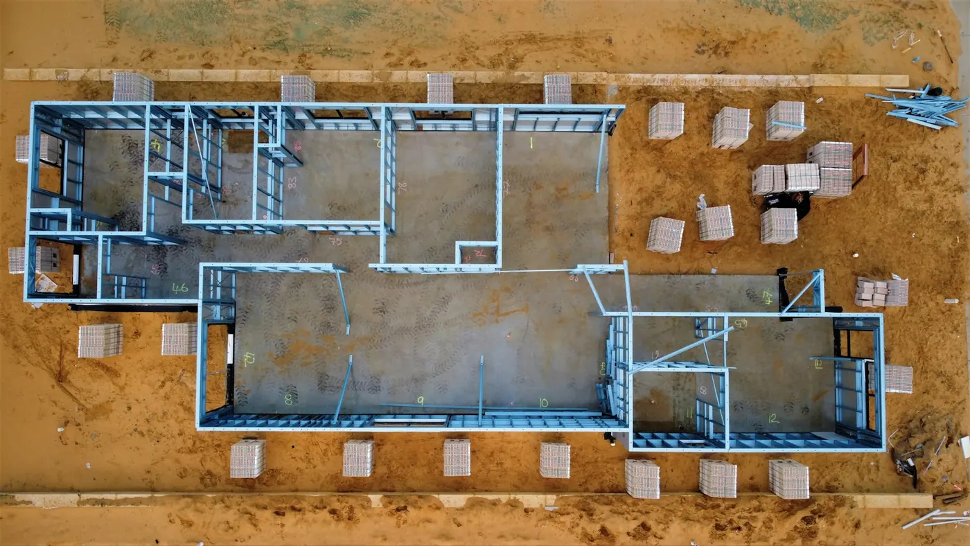 Overhead view of a building frame on a cleared lot