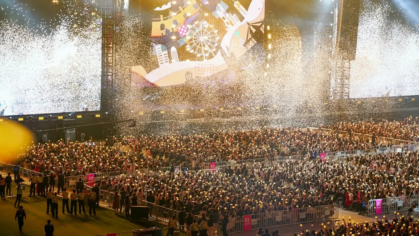 A packed concert crowd in front of a lit stage