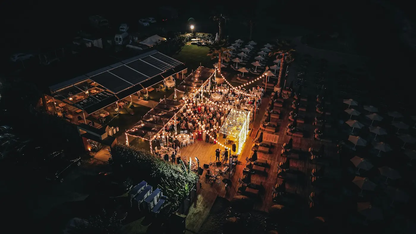 Aerial view of an outdoor night event lit with string lights