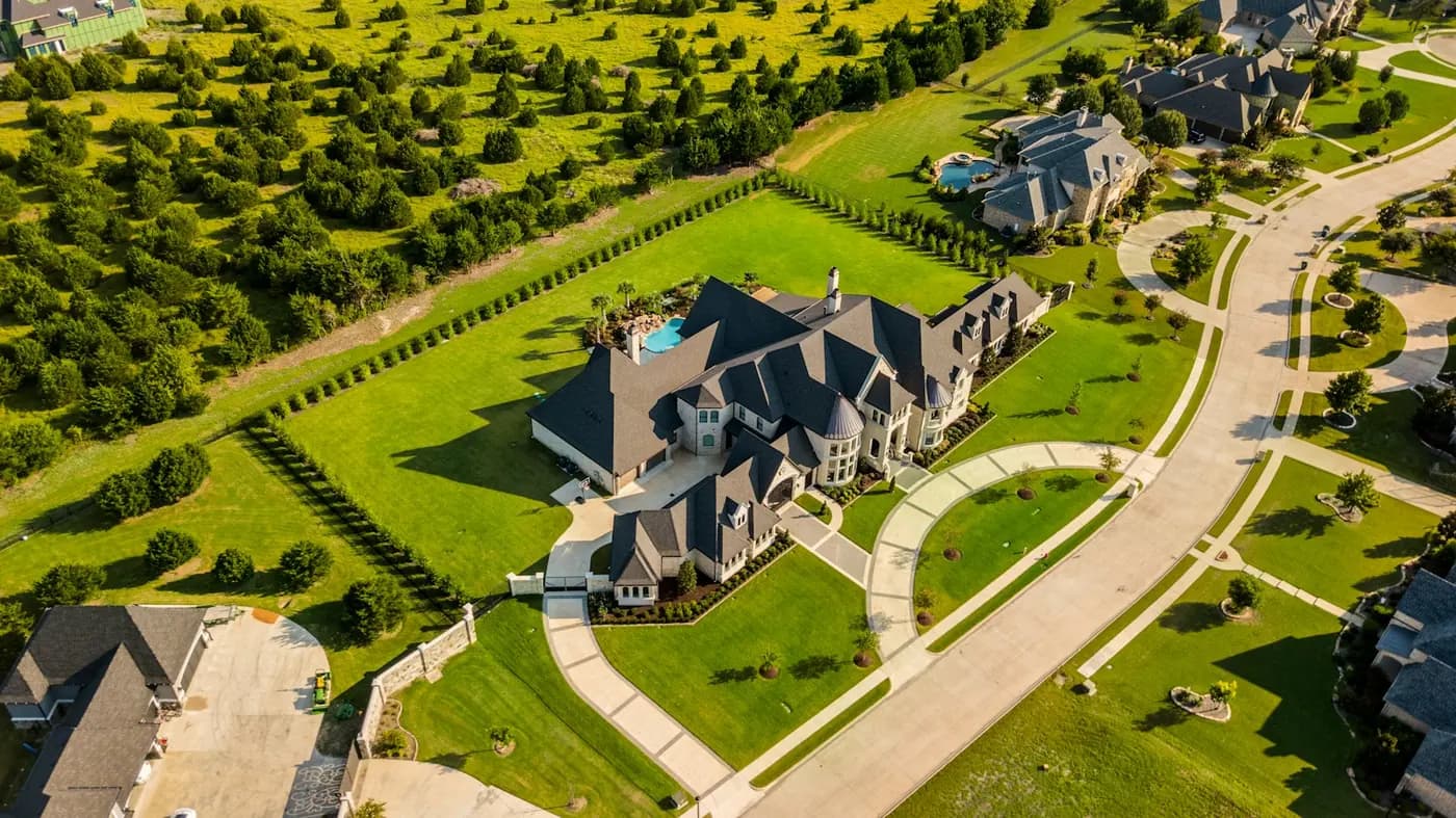 Aerial view of a large house with landscaped grounds