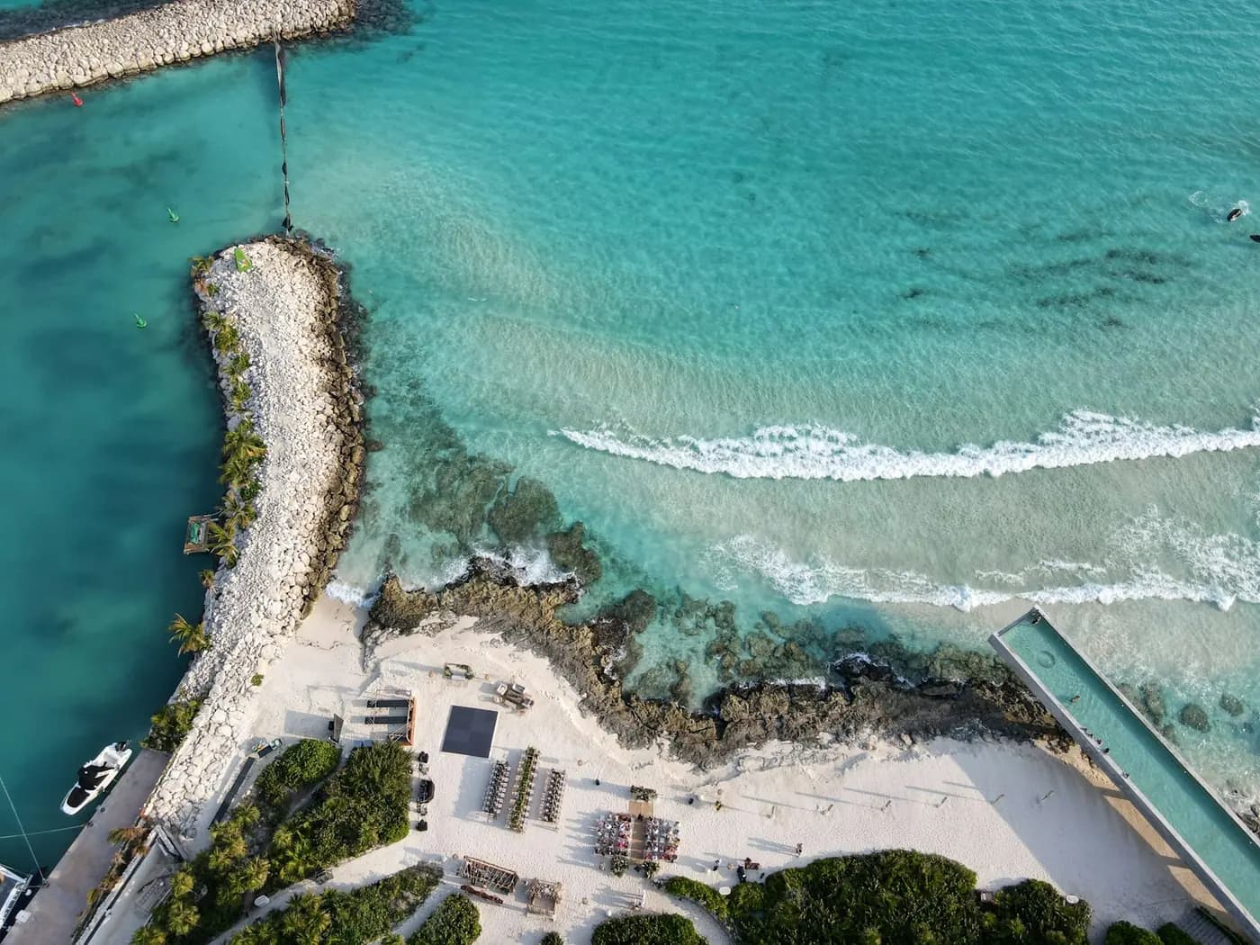 Aerial view of a rocky breakwater and turquoise water