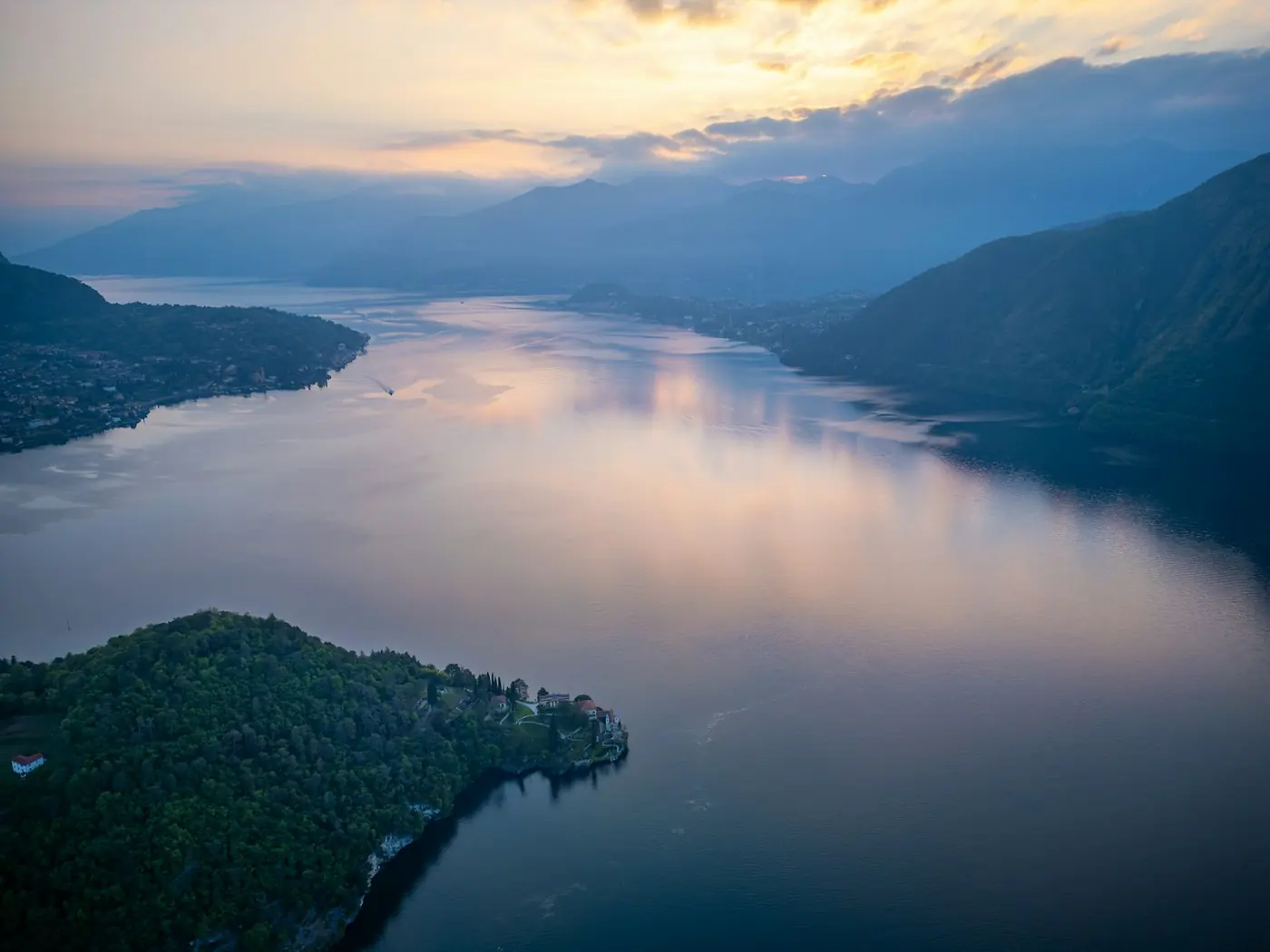 A lake between mountains at sunset, seen from the air