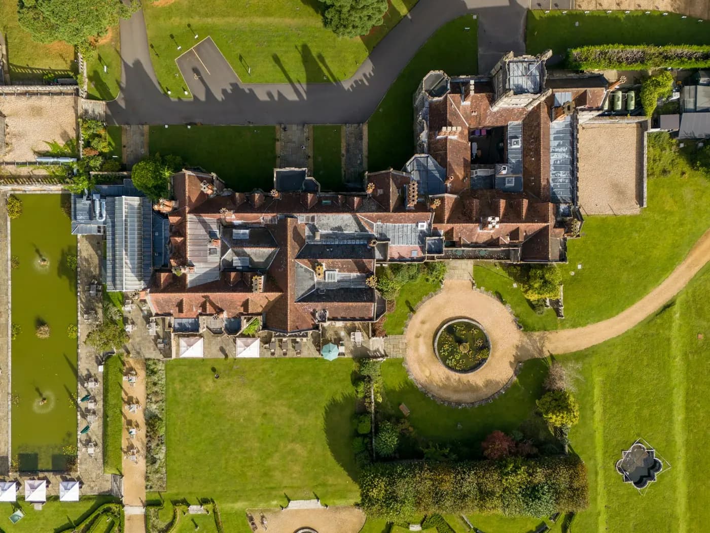 Aerial view of a historic manor house and formal gardens