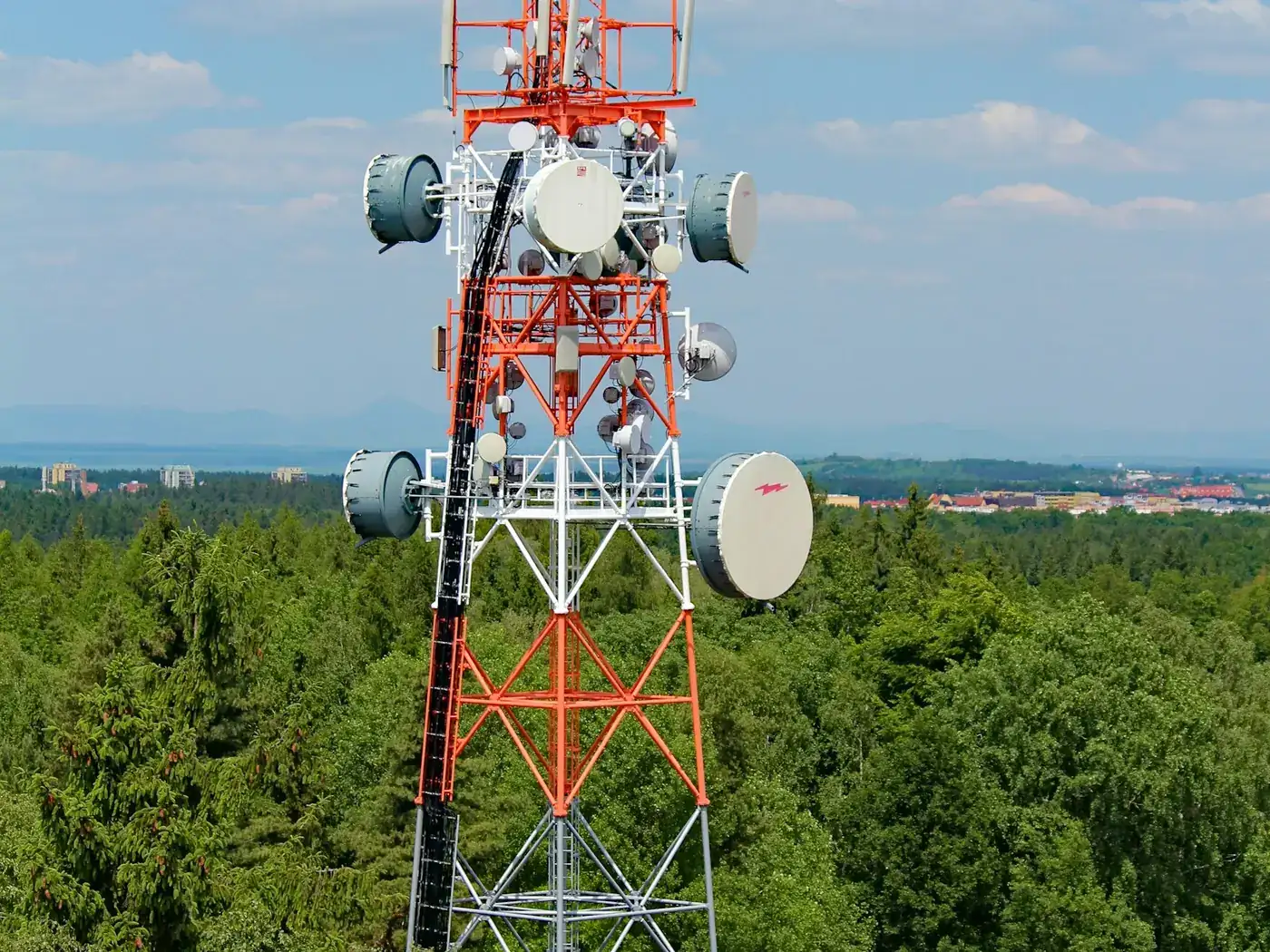 A lattice communications tower carrying antennas and microwave dishes