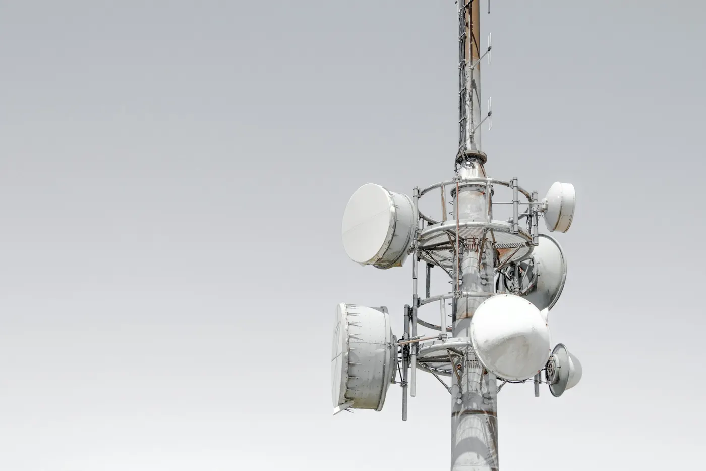 Parabole albe pentru microunde pe un pilon de telecomunicații