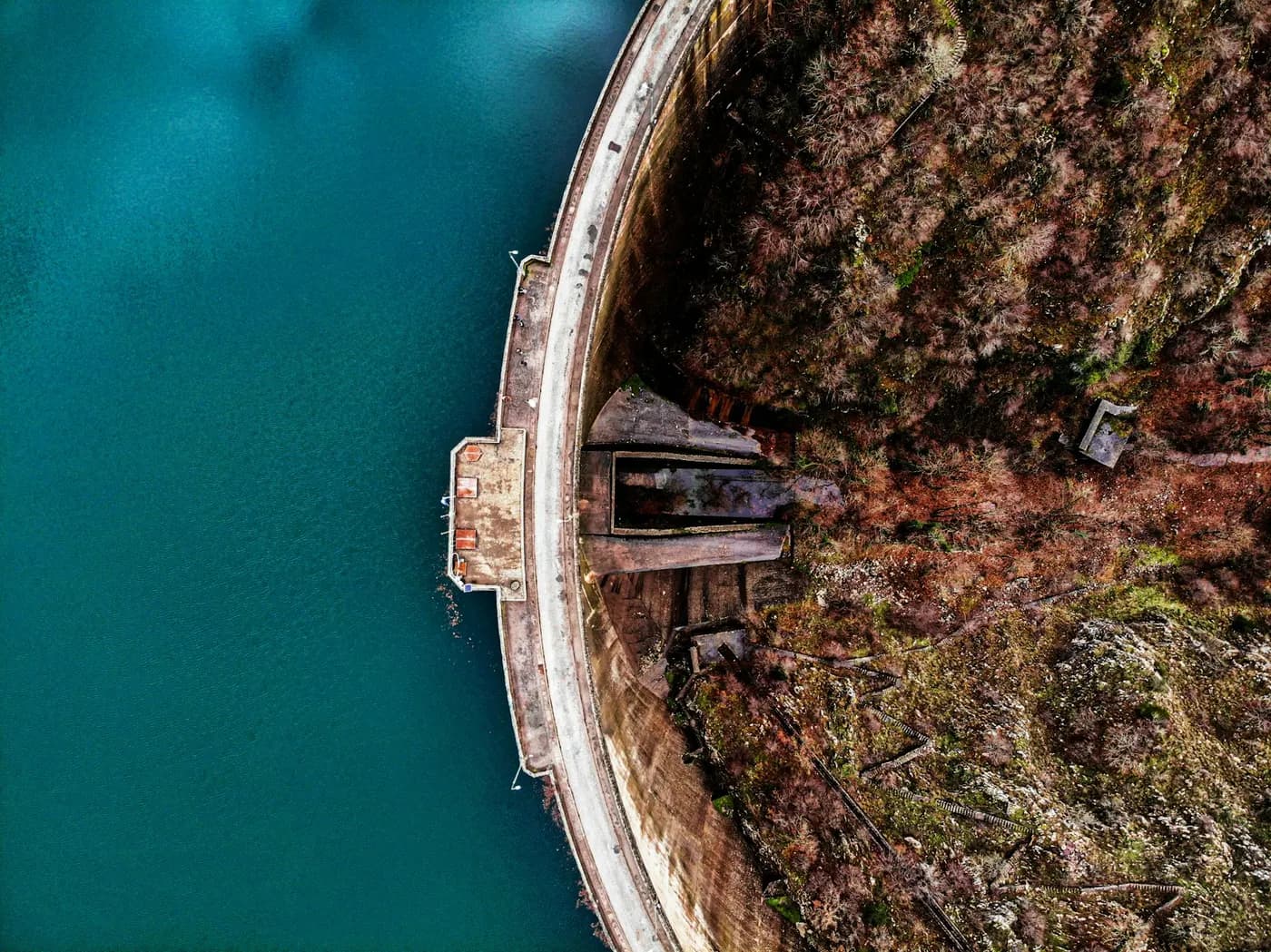 Vedere aeriană a unui baraj în arc lângă un lac de acumulare