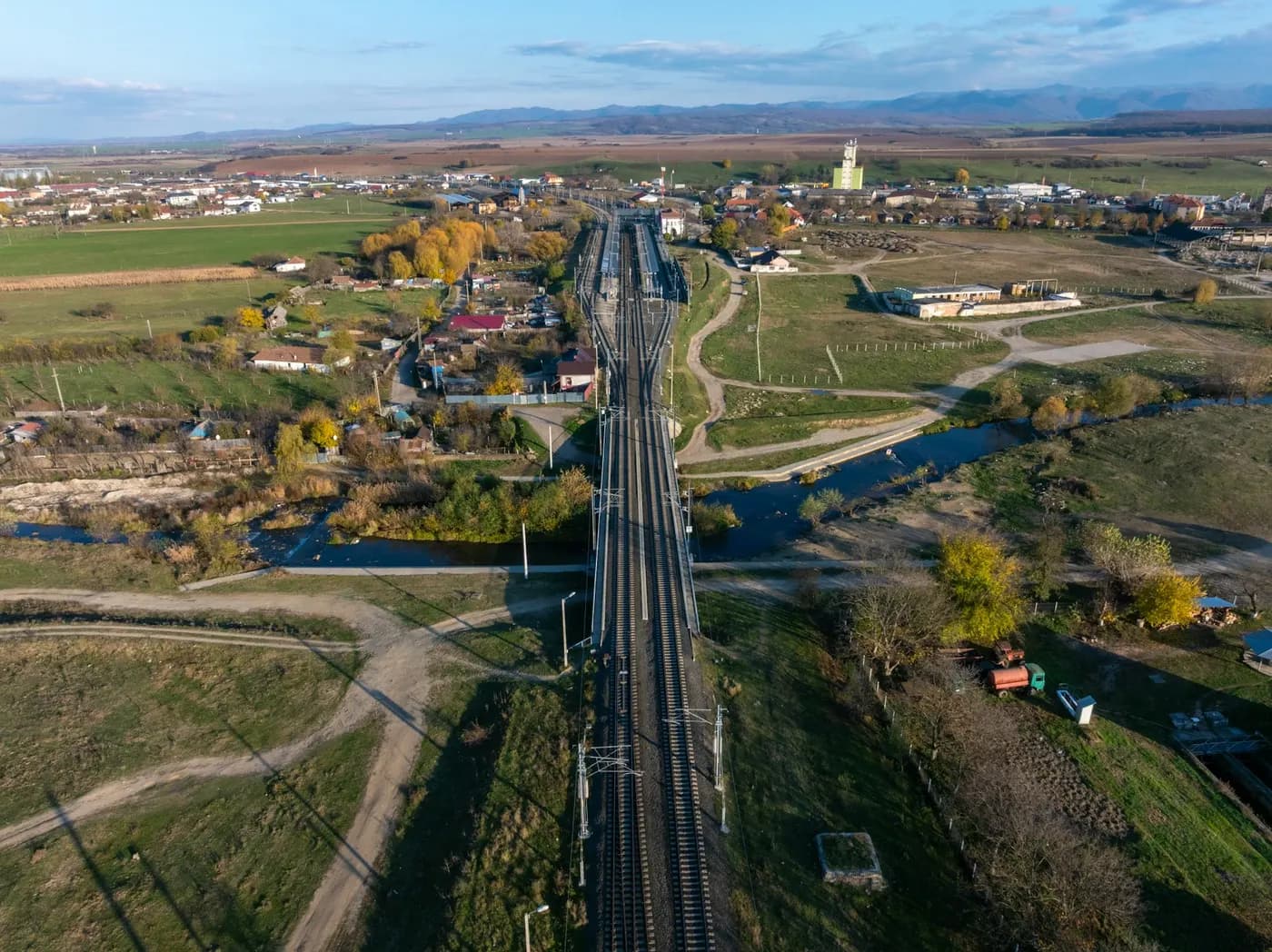 Aerial view of a railway line crossing farmland toward a town