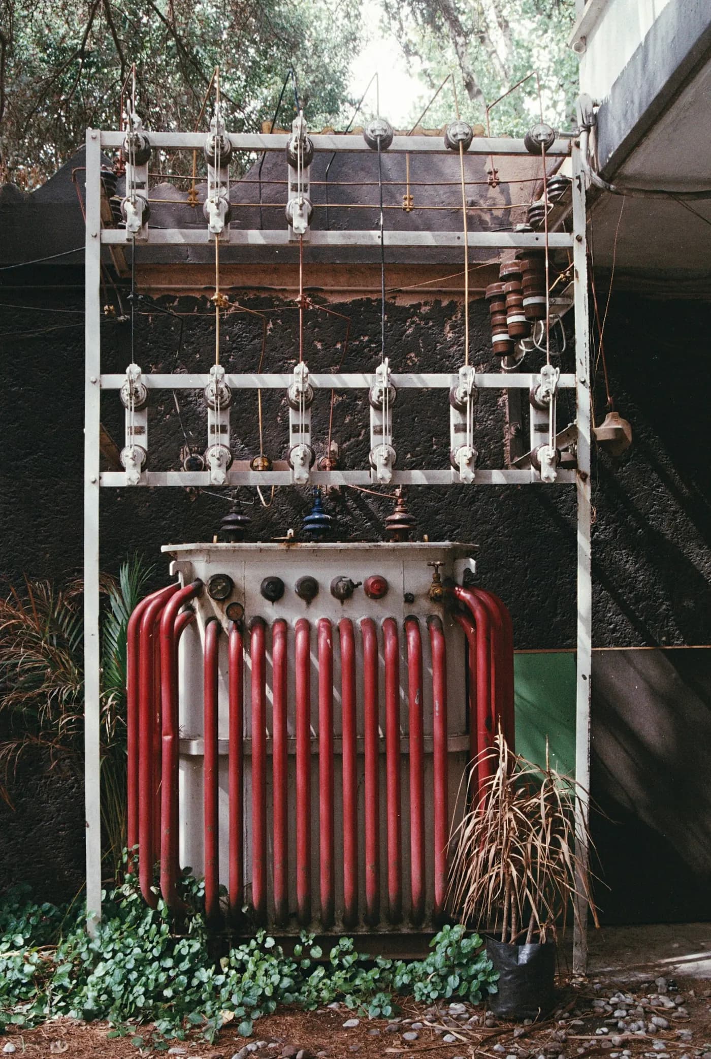 Transformer with red cooling fins inside a substation