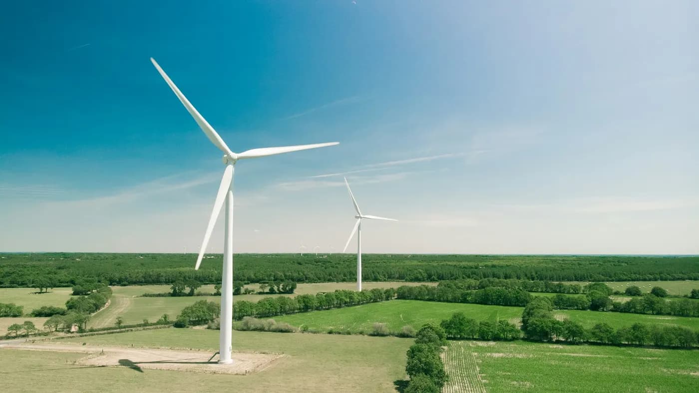 A wind turbine in farmland, seen from the air
